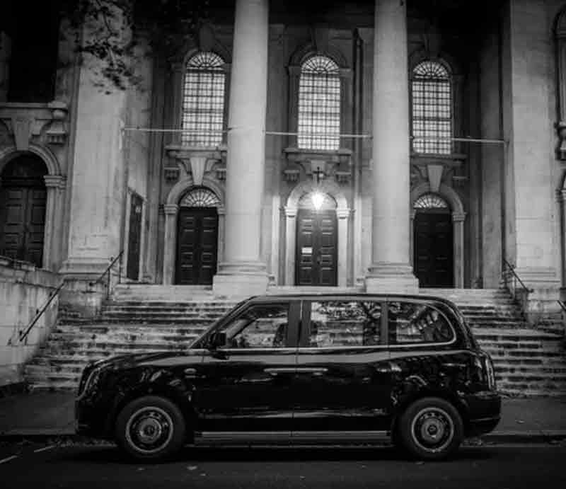 Moody black and white image outside a buidling with pillars.